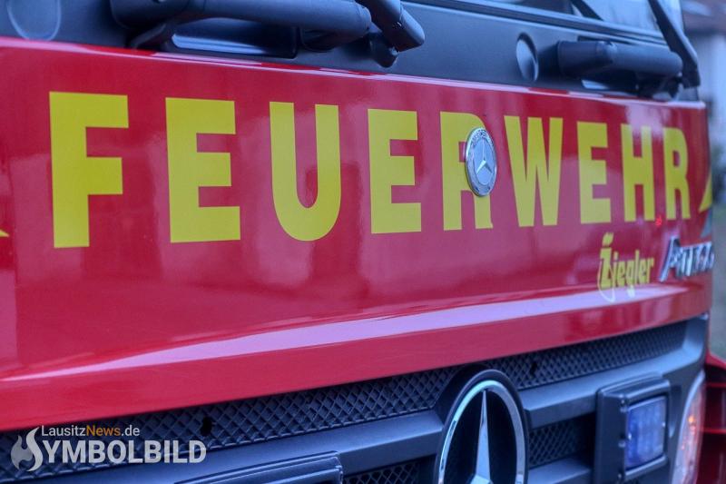 Kleidercontainer und Heuballen in Flammen