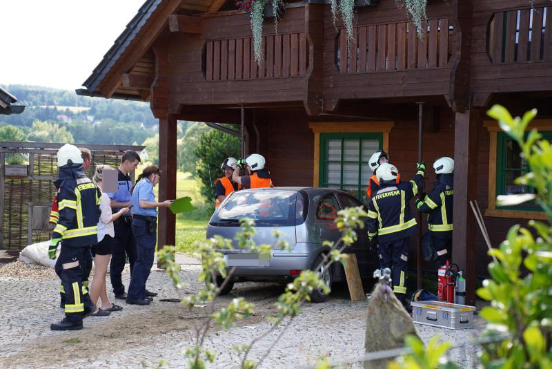 Opel rast durch Garten in ein Holzhaus